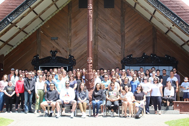 group of students and kaiako in front of the wharenui